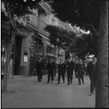 Robert Lacoste, ministre de l'Algérie, avec sa délégation, sur un trottoir d'Alger.