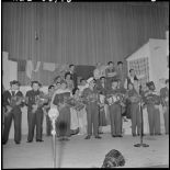 Les militaires de toutes armes reçoivent des bouquets de fleurs sur la scène du théâtre.