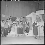 Une femme lit un texte sur la scène du théâtre.