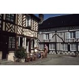 Beuvron-en-Auge (14). Terrasse de café et maisons traditionnelles.