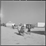 Centre de regroupement de M'Cid. Grande place avec des enfants à la fontaine, derrière la mairie.