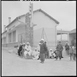 Monsieur Belkebich, maire de M'Cid, avec des administrés, devant l'école du centre de regroupement.