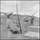 Portrait d'une combattante du groupe d'autodéfense de Catinat tenant son fusil.