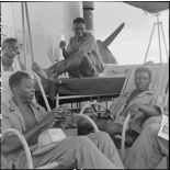 Des tirailleurs sénégalais libérés par le Vietminh se détendent à bord d'un chaland de débarquement les rapatriant vers Haïphong.