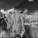 Des tirailleurs sénégalais libérés par le Vietminh reçoivent de la nourriture à bord d'un chaland de débarquement les rapatriant vers Haïphong.