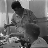 Des prisonniers libérés par le Vietminh se restaurent à bord d'un chaland de débarquement les rapatriant vers Haïphong.