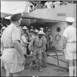 Des prisonniers libérés par le Vietminh débarquent d'un chaland de débarquement sur les quais d'Haïphong.