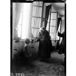 Toul (Meurthe-et-Moselle). Asile de Luxembourg. Croix-Rouge américaine. Infirmière offrant une pomme à un bébé. [légende d'origine]