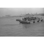 Des soldats et des chevaux traversent le cours d’eau à bord d’une barge.