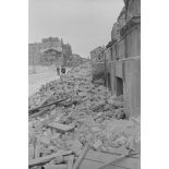 Route bordée de débris et de ruines.