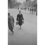 Dans la rue commerçante, une femme s’avance vers le photographe.