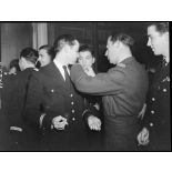 Le commandant du groupe de chasse Alsace attache la fourragère à l'un des pilotes.