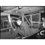 Charles Tillon prend place dans un avion stationné dans un atelier de l'usine Puteaux.