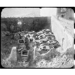 Vue en plongée sur des carcasses de voitures calcinées dans un garage du village martyr d'Oradour-sur-Glane.