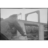 Un marin manoeuvre un grenadeur de sillage - à chaînes à maillons avec engrenage Galle - de grenades sous-marines à bord d'un chasseur de mines ou de sous-marins de la Marine nationale.