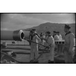 Ecouvillonnage d'un canon d'artillerie navale à bord d'un croiseur, probablement le croiseur lourd Duquesne.