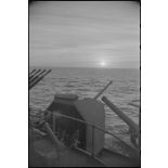 Coucher de soleil depuis un poste d'artillerie sous masque d'un navire de la Marine nationale.
