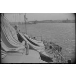 Une tente de camouflage est dressée sur la plage arrière d'un croiseur à quai.