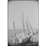 Equipage d'un croiseur à bord d'une baleinière à quai.