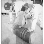 Deux marins manipulent un obus de 330 mm à bord du cuirassé Dunkerque.