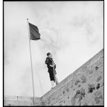 Une sentinelle d'une unité de défense côtière, canonnier marin algérien, dit Baharia, est en faction devant le mât des couleurs au fort de Mers-el-Kébir.