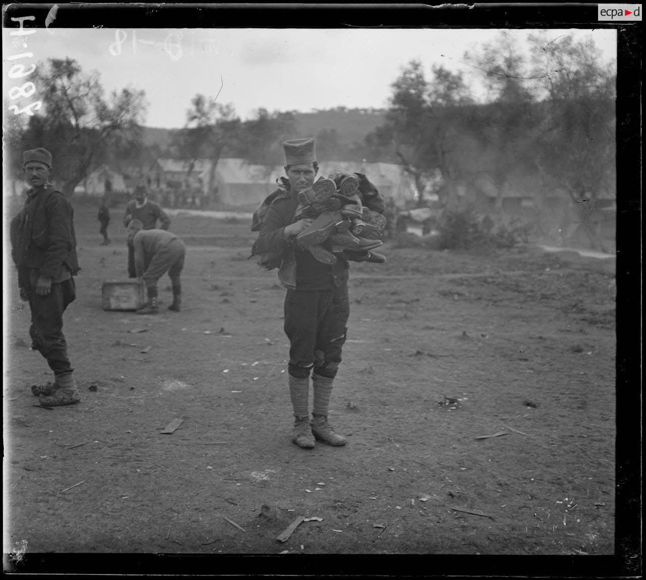 Govino. Camp de Serbes. Serbe portant un lot de chaussures neuves. [légende d'origine]