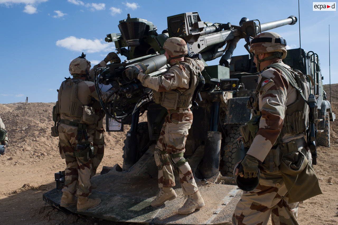 Des artilleurs du 3e régiment d'artillerie de marine (3e RAMa) chargent un obus dans le canon d'un camion équipé d'un système d'artillerie (CAESAR) à Al-Qaïm.