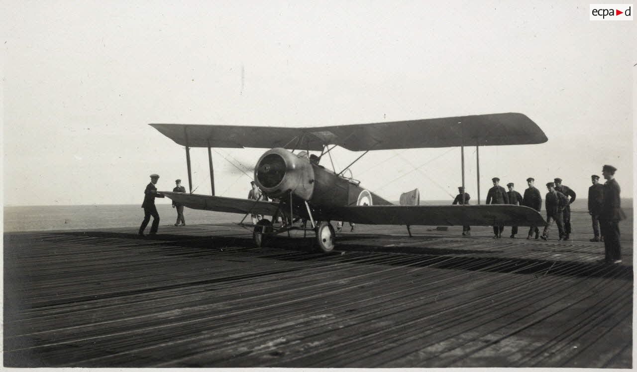 Mars 1920. Escadre anglaise à Alger. Le pont supérieur de l'"Argus", bateau porte-avions. L'avion atterrit : des pinces, plusieurs en-dessous de l'appareil, agrippent les cables en fer tendus parallèlement sur les planches et forment frein. [légende d'origine]