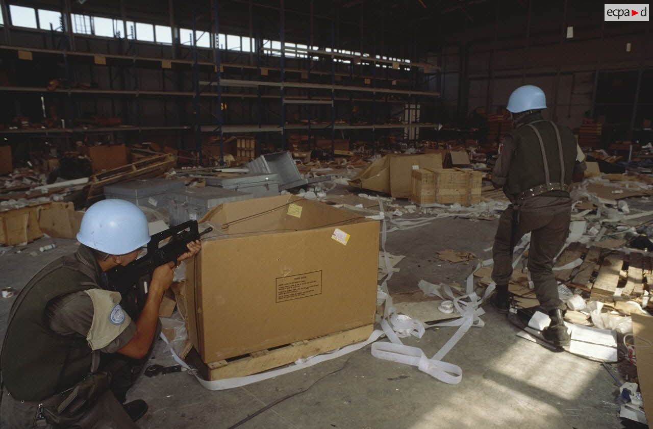 Des marsouins du 2e RIMa pénètrent dans un hangar dévasté de l'aéroport de Sarajevo.