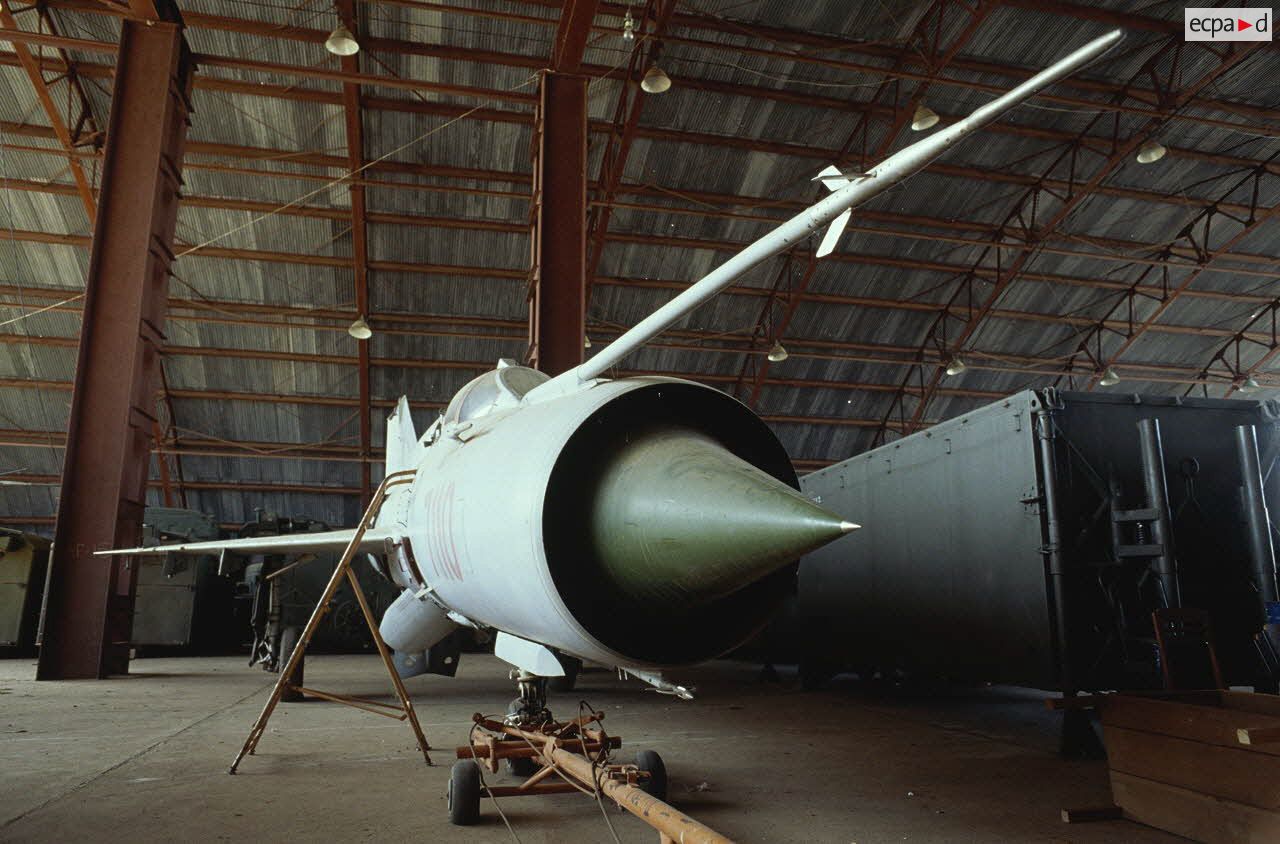 Avions à réaction Fishbed version B au sol entreposés dans un hangar.