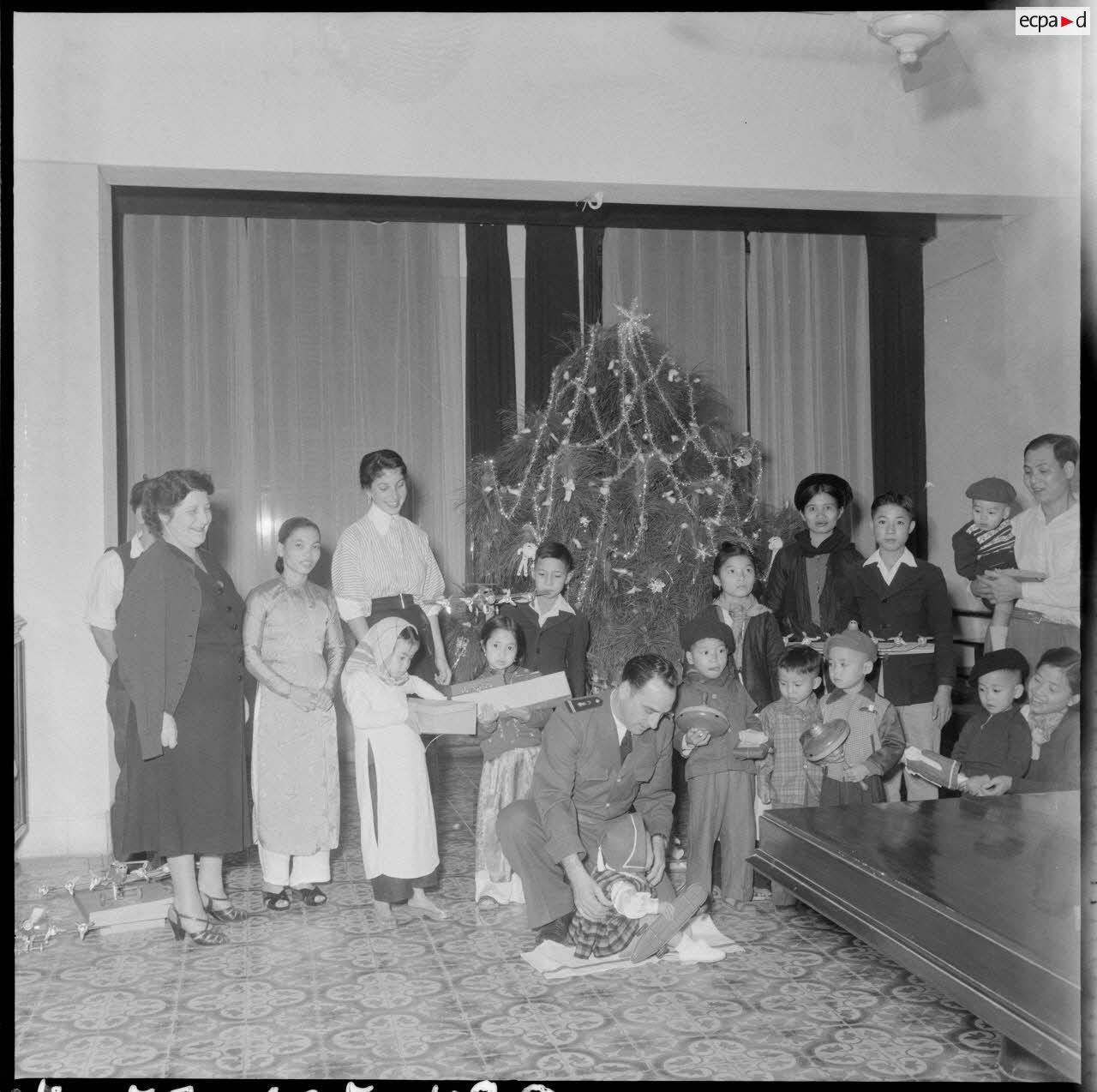 La fille (à côté du sapin) et l'épouse du général Cogny (à gauche), commandant en chef des FTNV (forces terrestres du Nord-Vietnam), lors d'une fête de Noël.