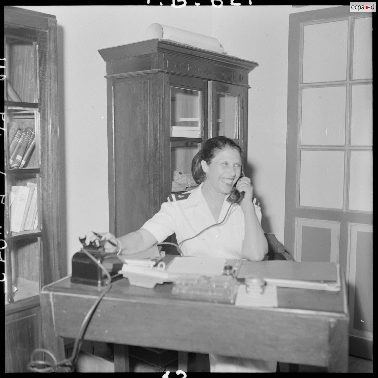 Woman wearing the uniform of the colonial troops talking on the phone in an office of the PFAT (female personnel of the Army) cantonment.