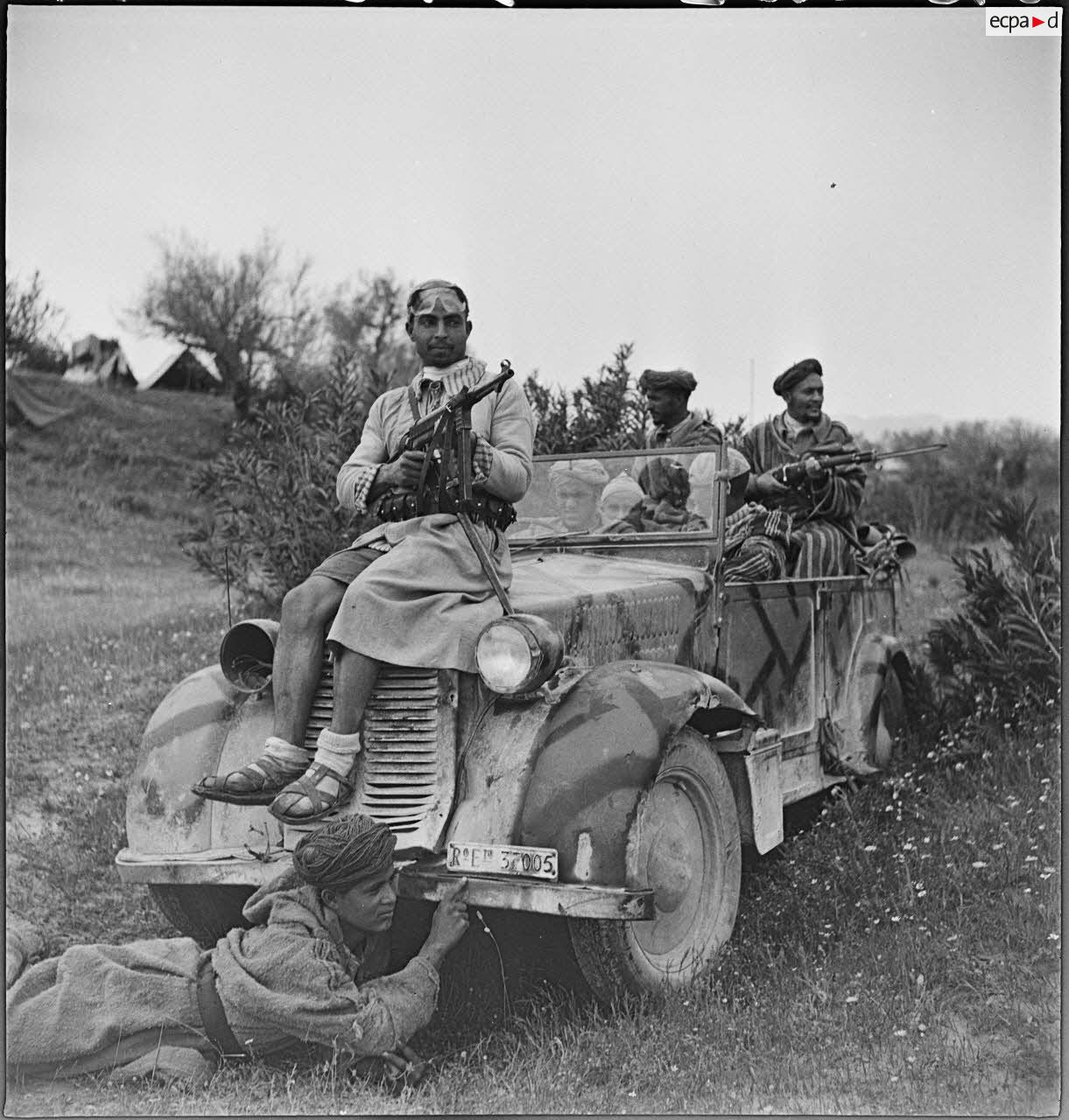 Des goumiers du IIe Tabor du 1er GTM (groupe de tabors marocains) de la 1re DMM (division de marche du Maroc) prennent la pose à bord d'une voiture de liaison FIAT 508 CM prise aux Italiens, dans le secteur de Siliana.