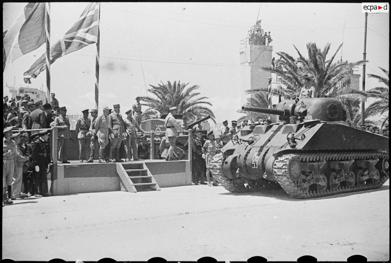 Depuis la tribune officielle, les autorités militaires assistent au défilé motorisé célébrant la victoire alliée à l'issue de la campagne de Tunisie.