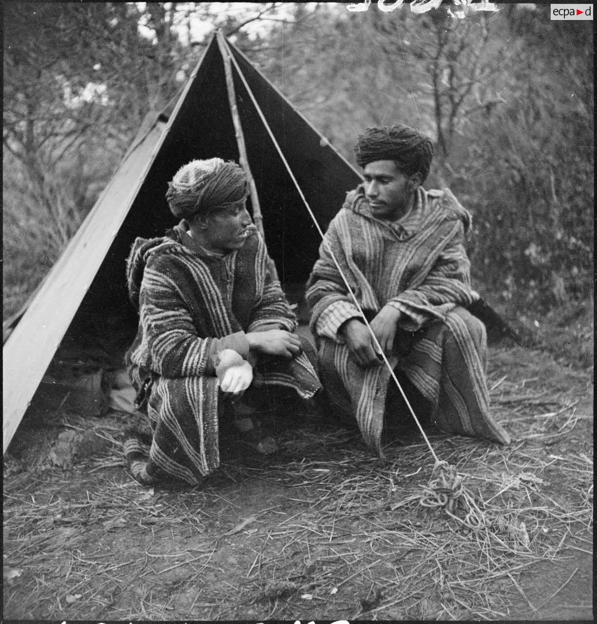 Supplétifs du 1er GSM (groupe de supplétifs marocains) de la 1re DMM (division de marche du Maroc) devant une tente dans le campement de l'unité.