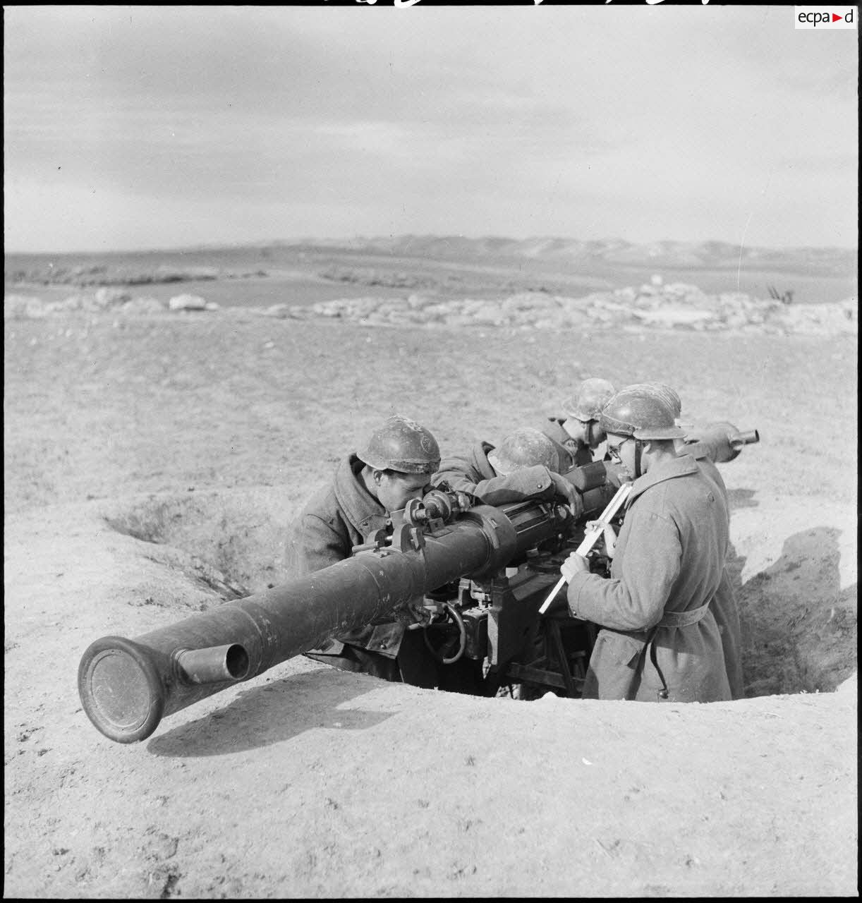 Des artilleurs du 412e RAAA (régiment d'artillerie antiaérienne) utilisent un télémètre stéréoscopique à échelle variable de batterie de 75 mm, dans le secteur de Bou Arada.