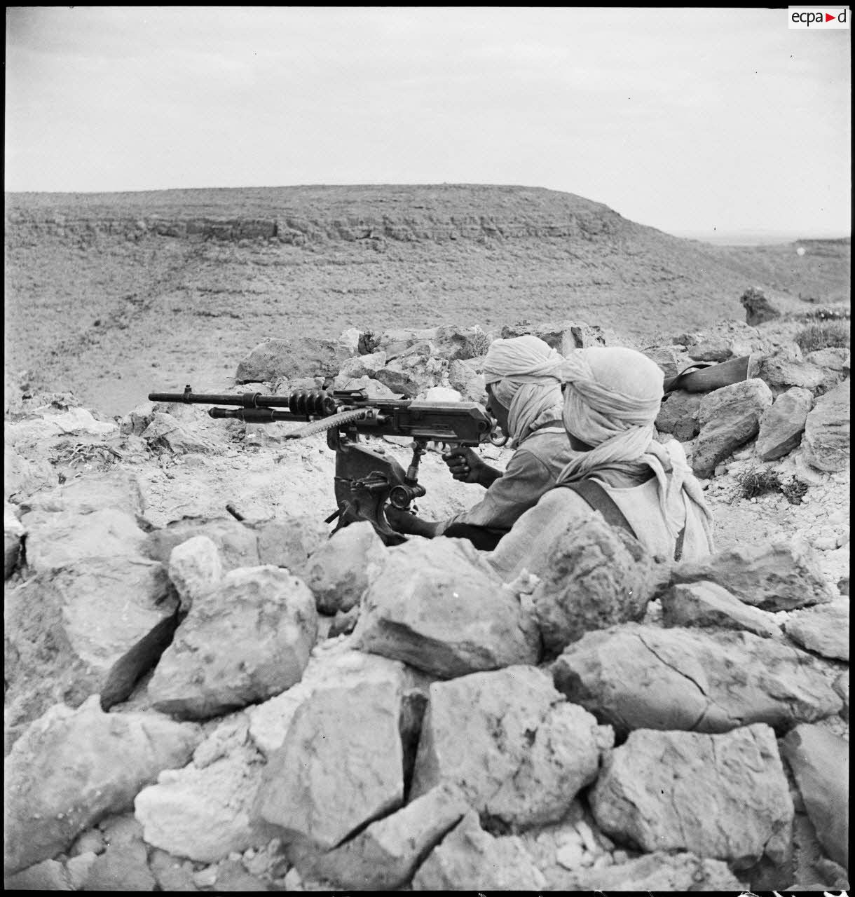 Mise en batterie d'une mitrailleuse Hotchkiss, modèle 1914, par des méharistes du groupement du capitaine Paganelli dans le secteur du FSEA. (Front sud-est algérien), entre le col de Bir el Asker et le Chott el Jerid.