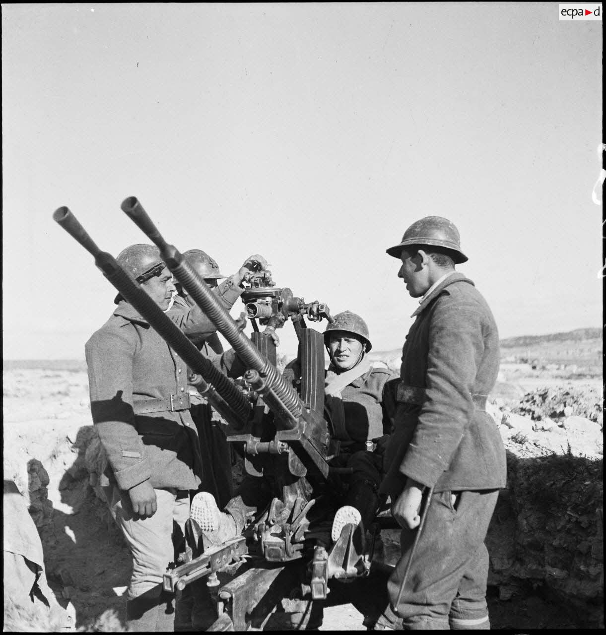 Des artilleurs du 411e RAAA (régiment d'artillerie antiaérienne) servent une mitrailleuse antiaérienne Hochkiss 13,2 mm sur affût bitube avec système de visée Le Prieur-Ricordel.