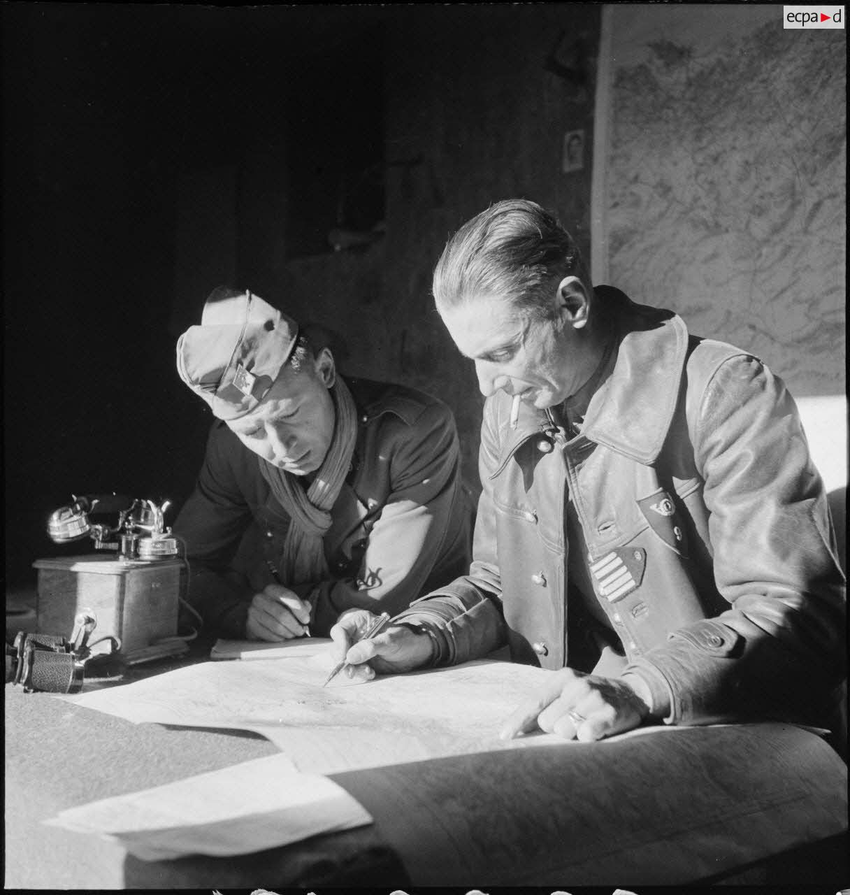 Le lieutenant-colonel Mazoyer, commandant le 9e RCA (régiment de chasseurs d'Afrique) rattaché à la BLM (brigade légère mécanique) et un lieutenant, font un point de situation sur une carte au poste de commandement du groupement Mazoyer, dans le secteur de Fondouk el-Okbi.