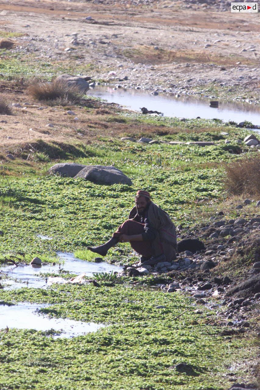 Un homme afghan se lavant dans un ruisseau.