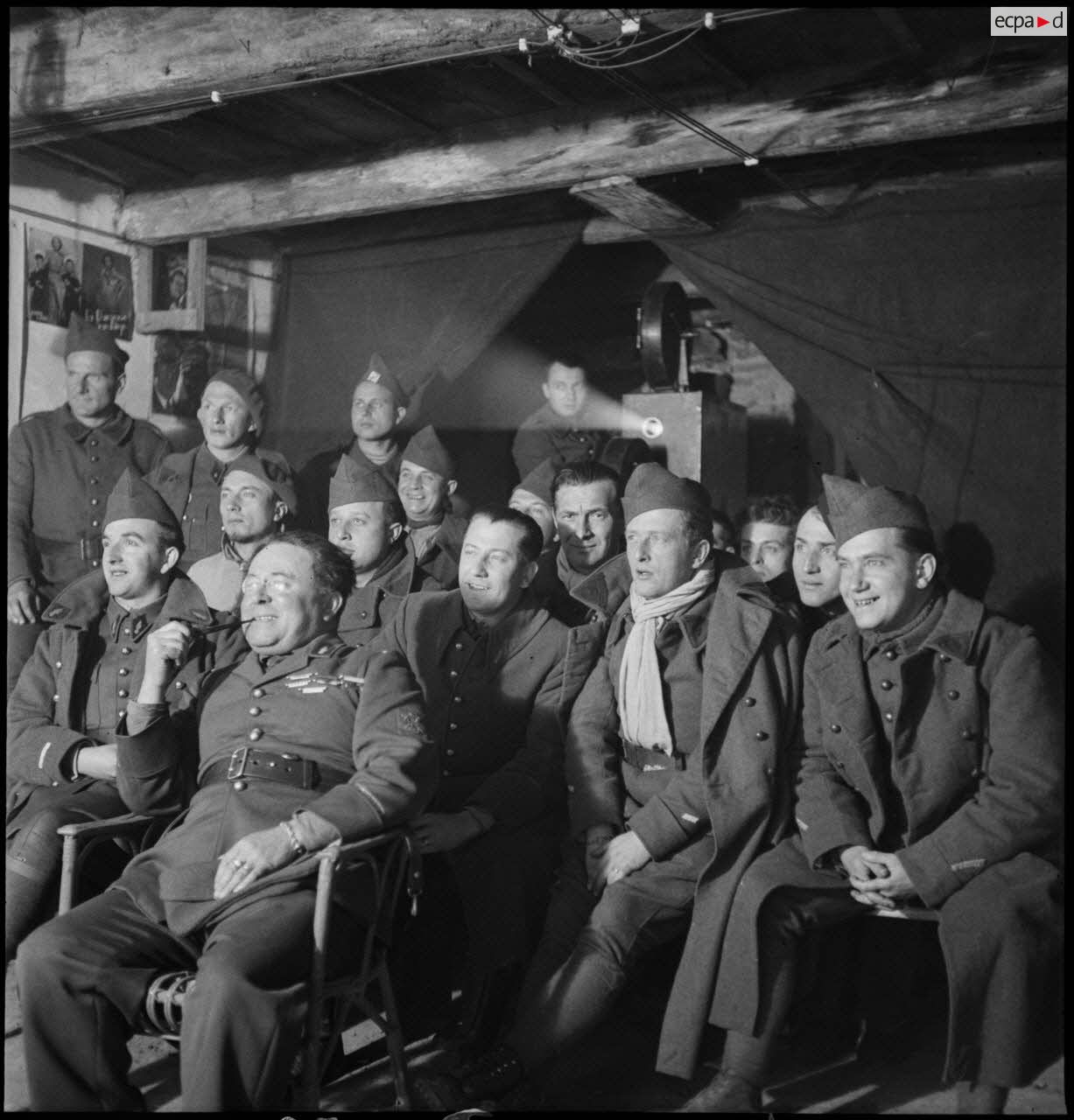 Photographie de groupe de soldats de différentes unités de la 2e armée qui assistent à une séance de cinéma aux armées.