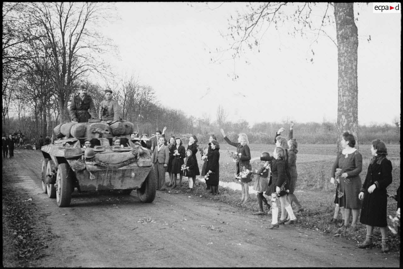 Automitrailleuse M8 du 3e escadron du 1er RMSM acclamée à son passage par la population des villages libérés.