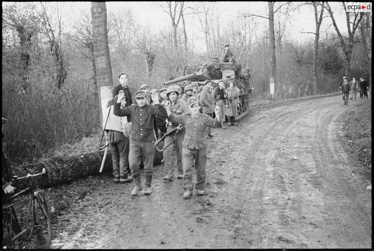 Prisonniers de guerre allemands conduits par des soldats de la 2e DB devant la population des villages libérés.