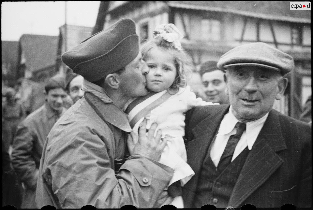 Scène de réjouissances et de liesse entre les soldats de la 2e DB (division blindée) et la population des villages libérés, probablement Blaesheim ou Hindisheim.