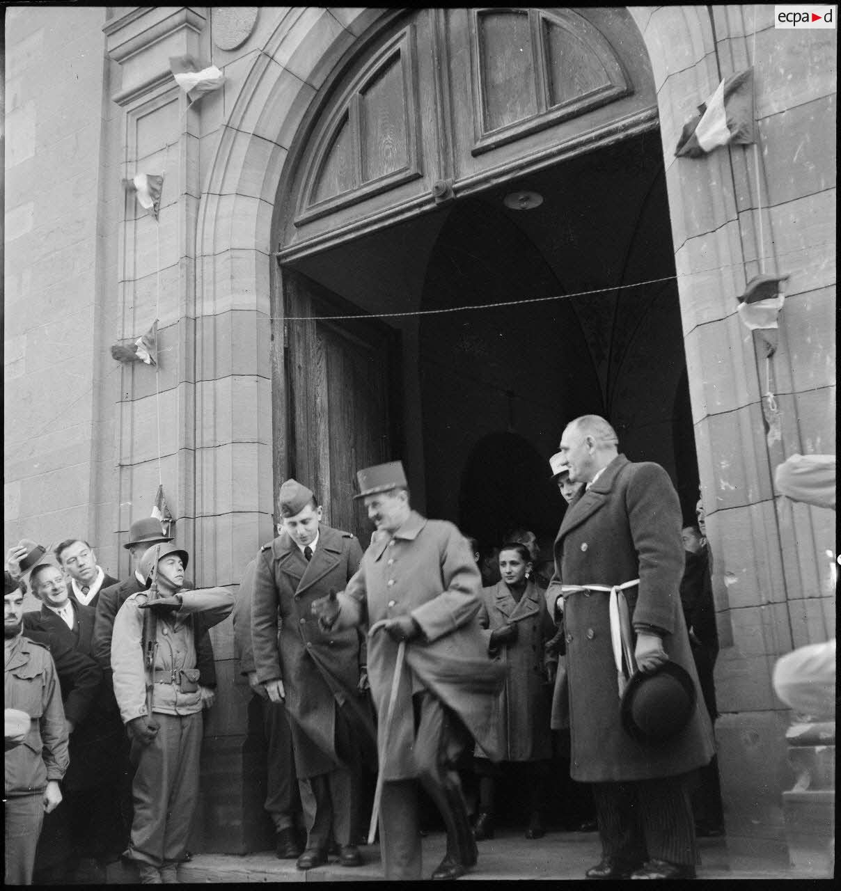 Le général Leclerc, commandant la 2e DB, et son aide de camp, le capitaine Girard (derrière le maire) sortent de l'église à Erstein (Bas-Rhin).