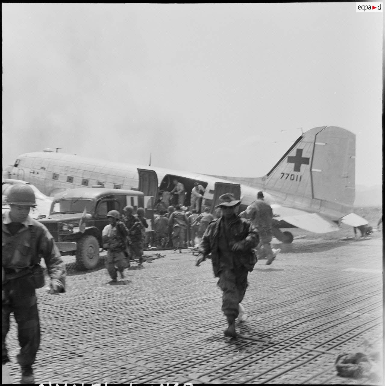 Embarquement de blessés à bord d'un avion Douglas C-47B skytrain (Dakota) au cours d'une évacuation sanitaire à Diên Biên Phu.