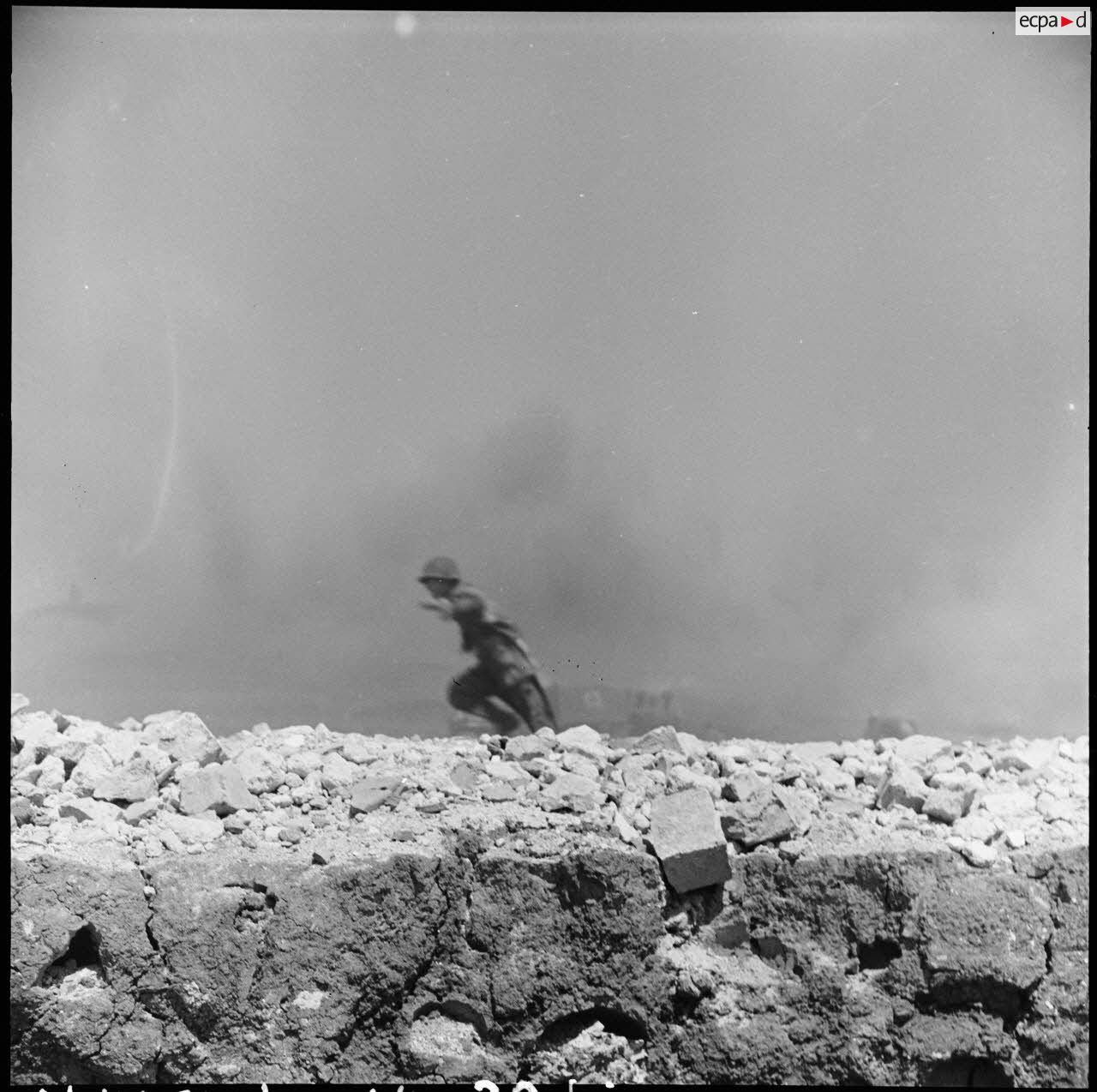 Soldat jaillissant dans la fumée des bombardements lors des combats de Diên Biên Phu.