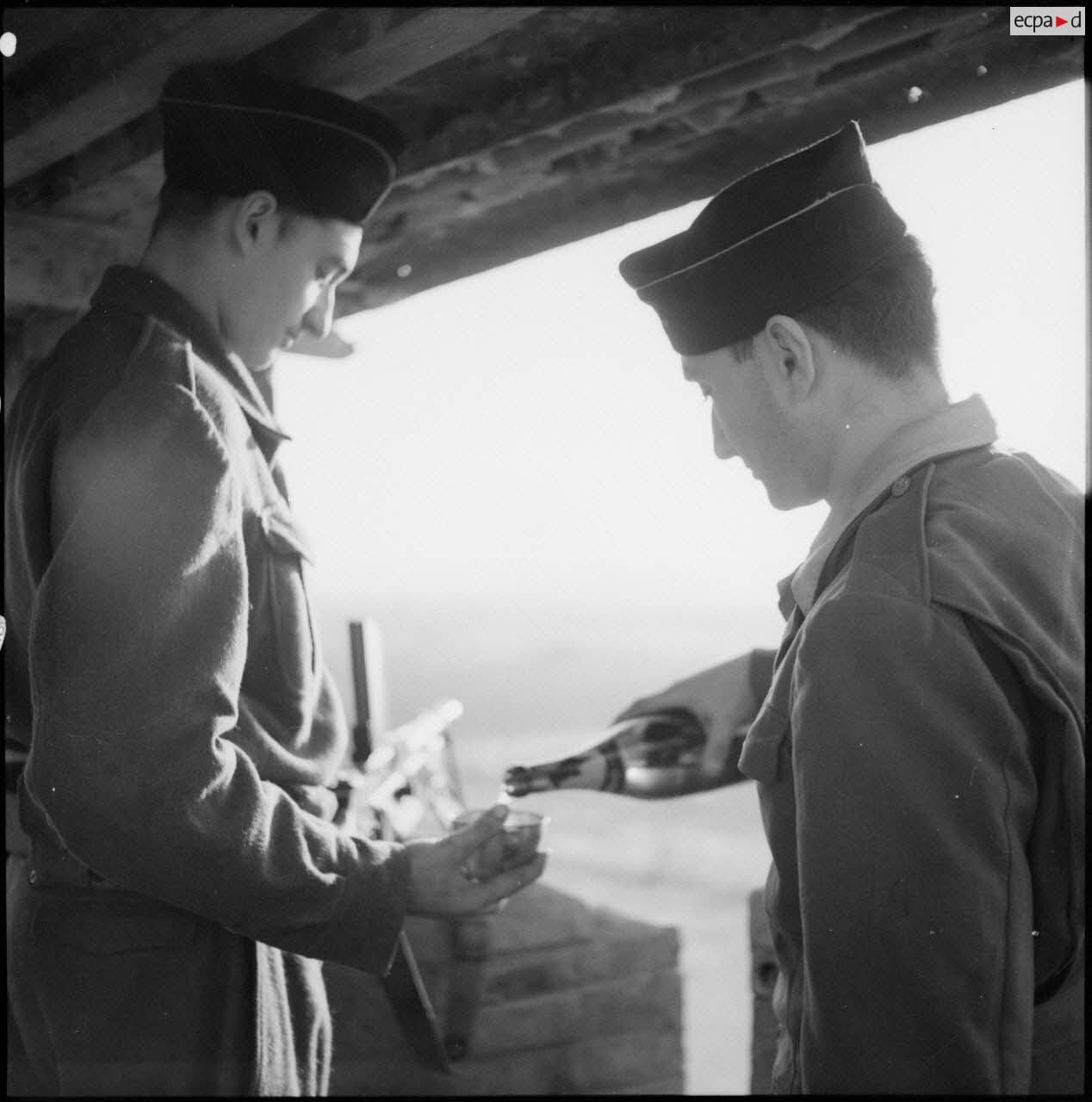 Un soldat sert un verre de champagne à une sentinelle surveillant un poste du delta du Tonkin.