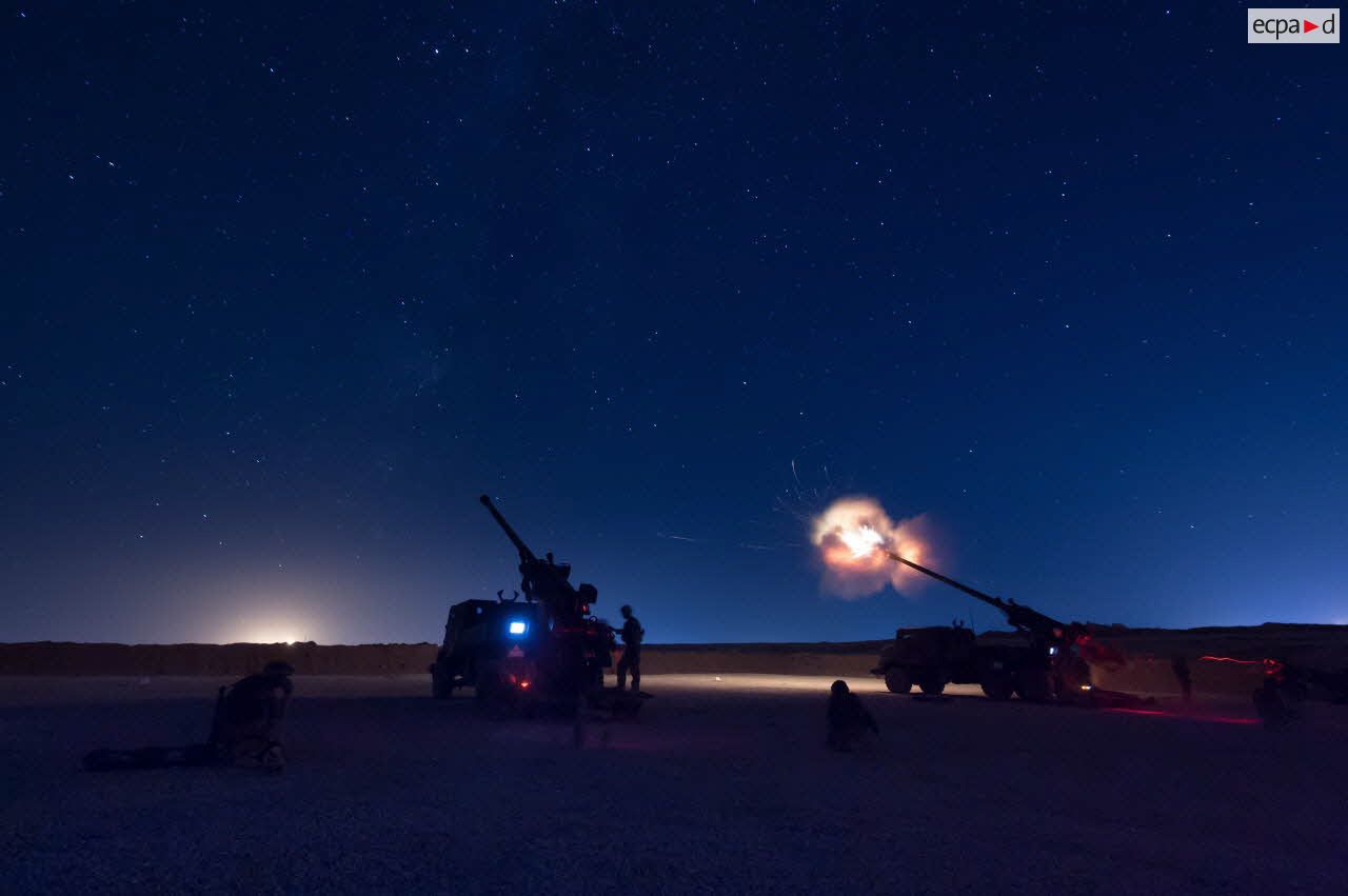 Tirs d'obus éclairants par deux camions équipés d'un système d'artillerie (CAESAR) de la première batterie du 93e régiment d'artillerie de montagne (93e RAM) à Filfayl, au nord de Mossoul.