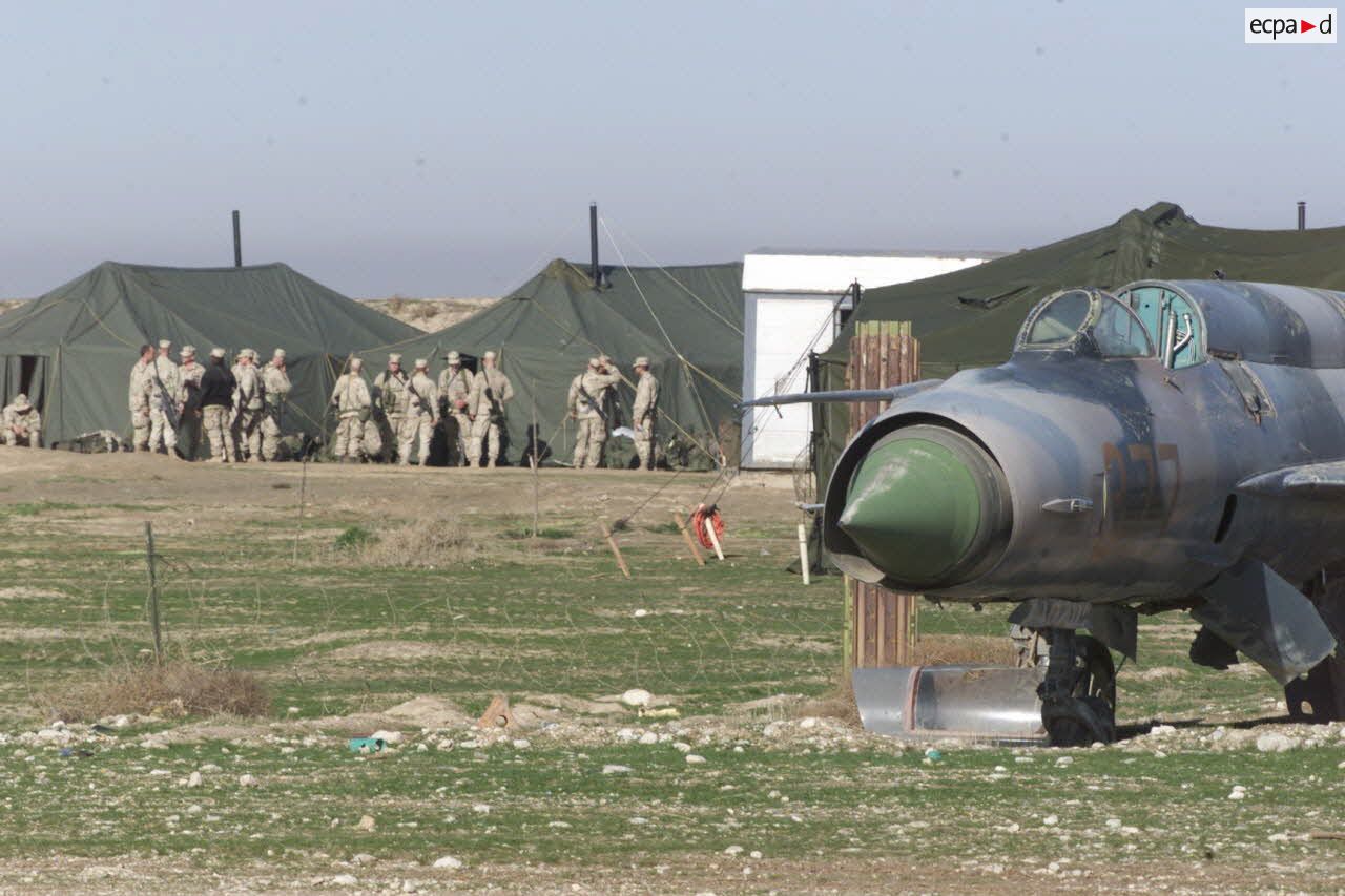 Campement américain à l'aéroport de Mazar e Charif. Au premier plan, l'épave d'un ancien avion de combat soviétique MIG.